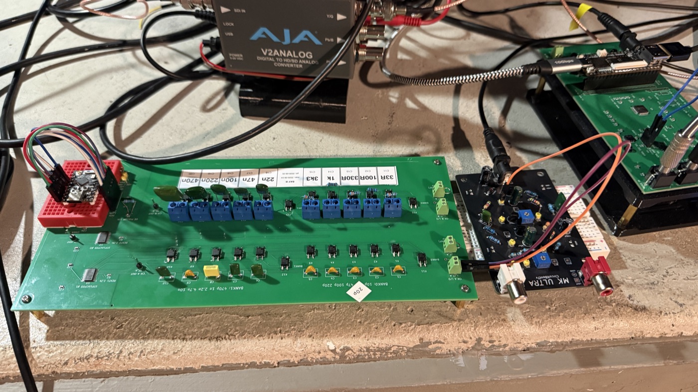 Workbench with hand-labeled circuit boards wired into a broadcast converter